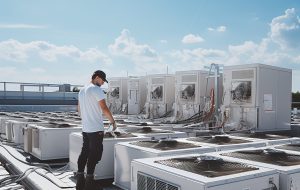 man working roof with large air conditioner